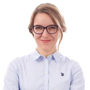 Marion Champoux-Pellegrin headshot, smiling woman with glasses in light blue shirt
