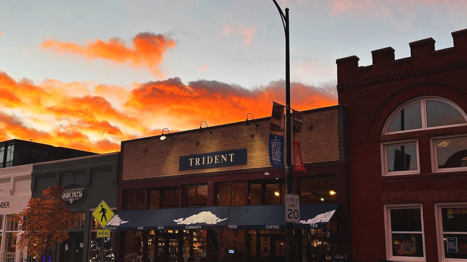Trident Booksellers & Café storefront at sunset with orange clouds {{brizy_dc_image_alt entityId=