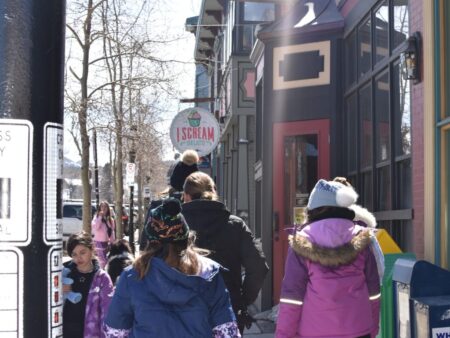 Children walking along Breckenridge sidewalk past I Scream Gelato shop on sunny winter day